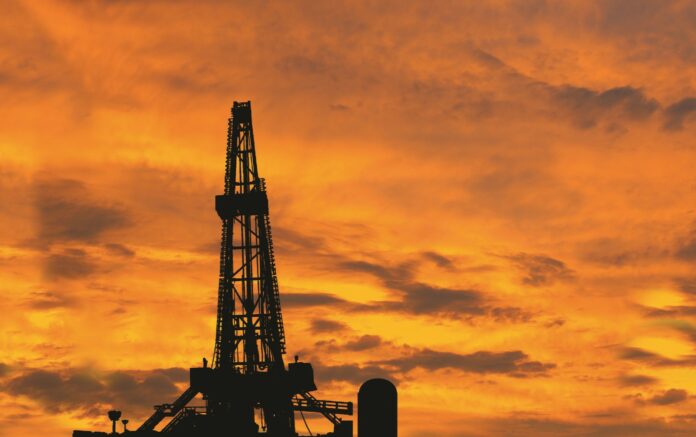 Silhouette image of oil and gas drilling rig in the middle of nowhere with dramatic sky