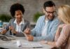 happy-man-talking-his-wife-while-using-touchpad-meeting-with-real-estate-agent-office