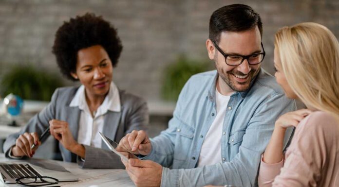 happy-man-talking-his-wife-while-using-touchpad-meeting-with-real-estate-agent-office